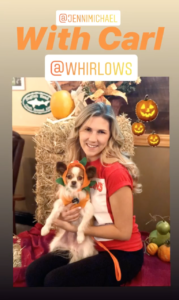 Photo of woman holding dog at Halloween event.